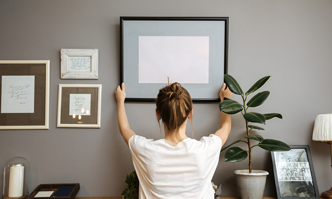 woman-decorating-home-gallery-wall-picture-fram-home-decor